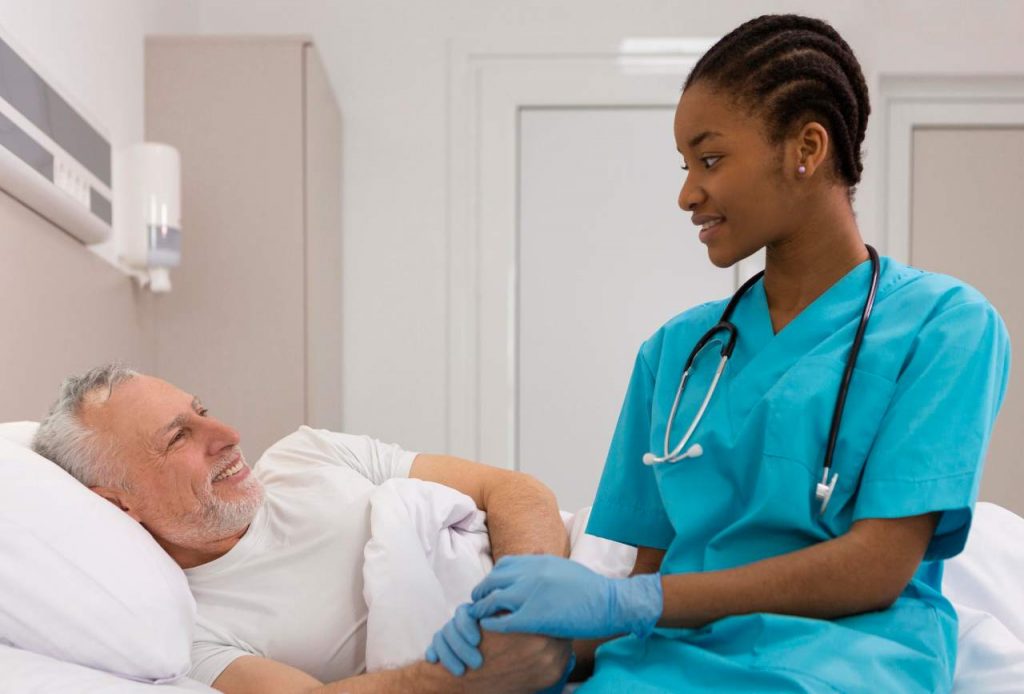 Enfermera sonriente vestida de azul con un paciente