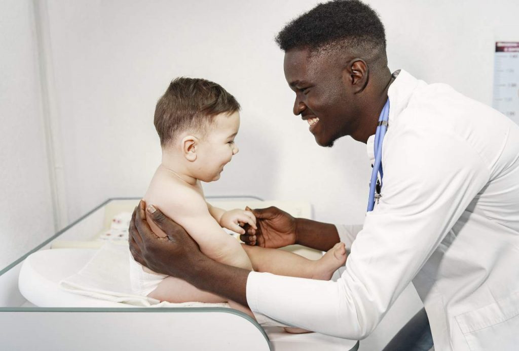 Enfermero de pediatría sonriente con un bebe