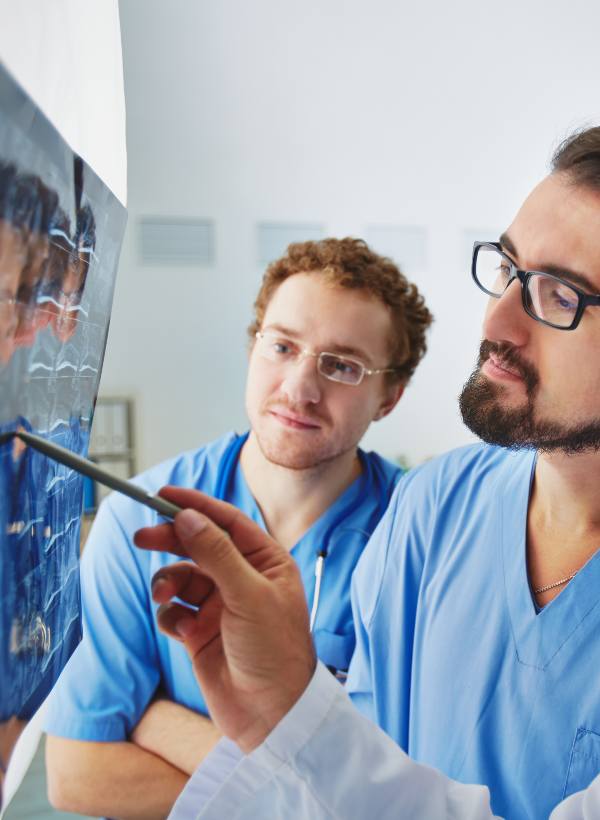 Médicos hombres vestidos de azul viendo una radiografía